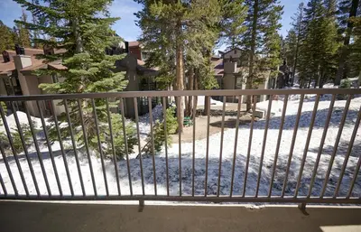 a gate to a balcony with snow and trees at St Anton Condos #83 condo in Mammoth Lakes