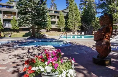 a statue of a bear and flowers in front of a building at St Anton Condos #83 condo in Mammoth Lakes