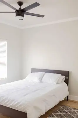 a bedroom with a white bed with a ceiling fan at Gateway Retreat: Short Drive to the Sequoias in Exeter