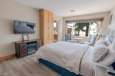 a bedroom with a bed with a tv and a fireplace at Lakeside Hotel room #5 in Kings Beach in Kings Beach