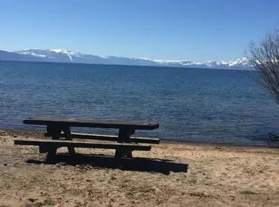 a picnic table sitting on the shore of a lake at Lakeside Hotel room #5 in Kings Beach in Kings Beach