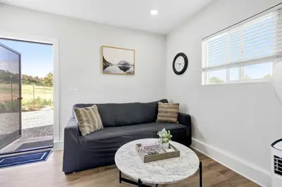 a living room with a couch and a table at Country Charmer Single Story Cottage Pet Friendly in Loomis