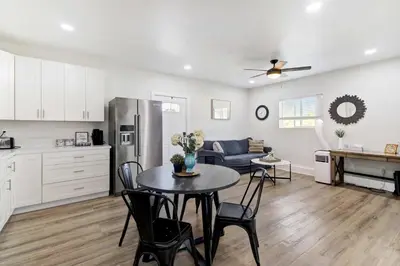 a kitchen and living room with a table and chairs at Country Charmer Single Story Cottage Pet Friendly in Loomis