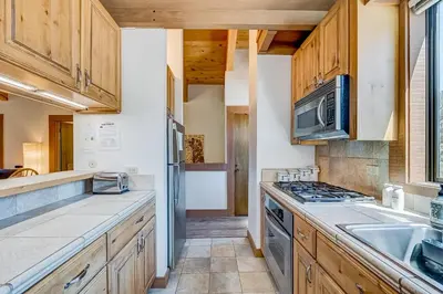 a kitchen with wooden cabinets and a stove top oven at Silver Strike Sanctuary in Truckee