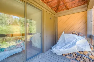 a glass door on a porch with a pile of wood at Silver Strike Sanctuary in Truckee
