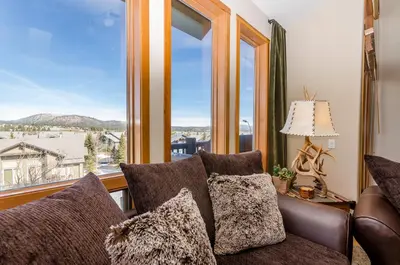 a living room with a couch and a large window at Snowcreek V 984 in Mammoth Lakes