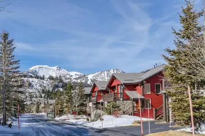 a red house with snowy mountains in the background at Snowcreek V 984 in Mammoth Lakes