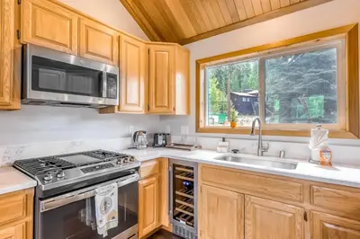 a kitchen with a stove and a sink and a window at Basque in Nature in Truckee