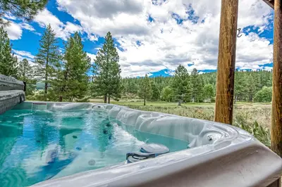 a jacuzzi tub in a field with trees at Basque in Nature in Truckee