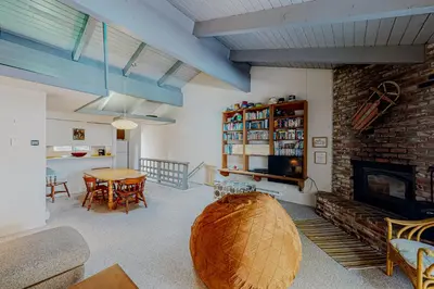 a living room with a table and a fireplace at Falcon Nest in Incline Village
