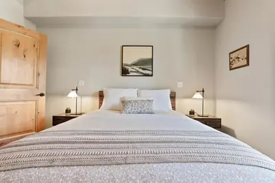 a bedroom with a large bed with two lamps at Modern Condo - EV Plug In - SM 301 in Bear Valley