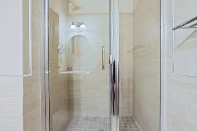 a shower with a glass door in a bathroom at Modern Condo - EV Plug In - SM 301 in Bear Valley