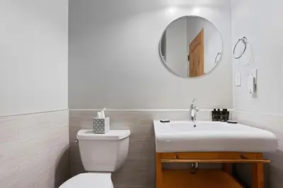 a bathroom with a toilet and a sink and a mirror at Modern Condo - EV Plug In - SM 301 in Bear Valley