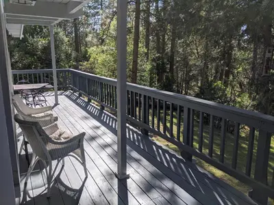 a porch with two chairs and a table on it at Breckenridge Chalet near Yosemite. Dog friendly! in Groveland