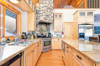 a large kitchen with wooden cabinets and a sink at Oso Lodge in Yosemite West