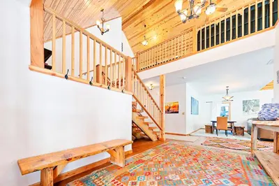 a staircase in a home with a wooden ceiling at Oso Lodge in Yosemite West