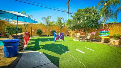 a backyard with a playing field with an umbrella at Tropical Paradise in Fresno
