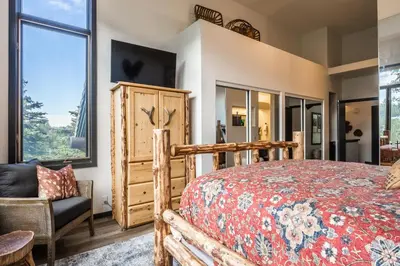 a bedroom with a bed and a chair and windows at Great Views Fully Renovated Luxury 4 Bedroom 3 Full Bathrooms and Half Bath Snowcreek 732 Phase V in Mammoth Lakes