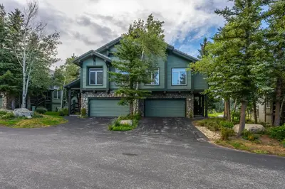 a green house with a driveway at Great Views Fully Renovated Luxury 4 Bedroom 3 Full Bathrooms and Half Bath Snowcreek 732 Phase V in Mammoth Lakes