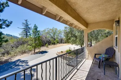 a balcony with two chairs and a view of a road at Colfax Getaway with Hot Tub, Mountain Views! in Colfax