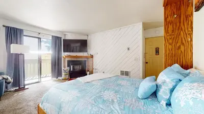 a bedroom with a blue bed with a fireplace at La Vista Blanc #59 condo in Mammoth Lakes