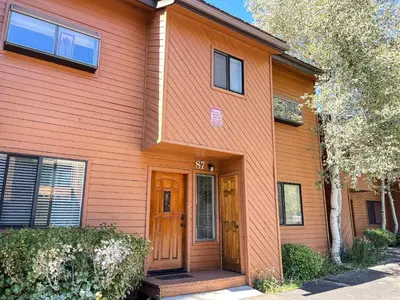 a orange house with a wooden door at Snowflower #87 condo in Mammoth Lakes