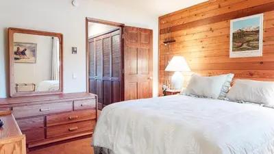 a bedroom with a bed and a large mirror at Snowflower #87 condo in Mammoth Lakes