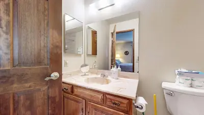 a bathroom with a sink and a mirror and a toilet at Snowflower #87 condo in Mammoth Lakes