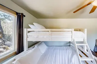 a bedroom with two bunk beds and a window at Cascadel Hideaway in North Fork