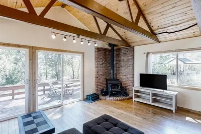 a living room with a fireplace and a television at Cascadel Hideaway in North Fork