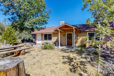 a house with a yard with benches and trees at Cascadel Hideaway in North Fork