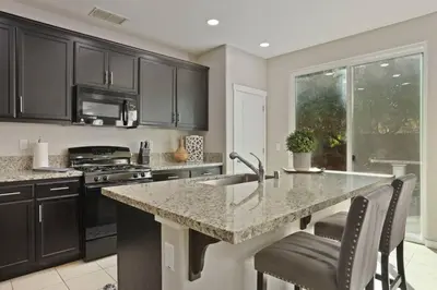 a kitchen with black cabinets and a granite counter top at Stunning River Islands Home Near Lake & Boat House in Lathrop