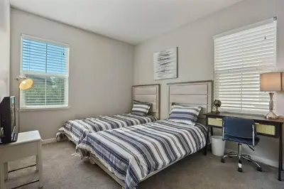two beds in a room with a desk and a desk at Stunning River Islands Home Near Lake & Boat House in Lathrop