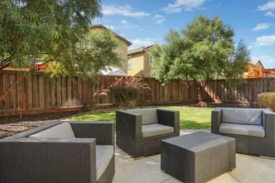 a patio with wicker chairs and tables in a yard at Stunning River Islands Home Near Lake & Boat House in Lathrop