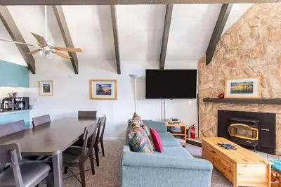 a living room with a table and a couch and a fireplace at Perfect Ski Rental 2 blocks from Village Gondola in Mammoth Lakes