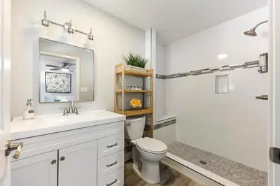 a white bathroom with a toilet and a shower at Fully Renovated 4 Bedroom Home with Pool! in Roseville