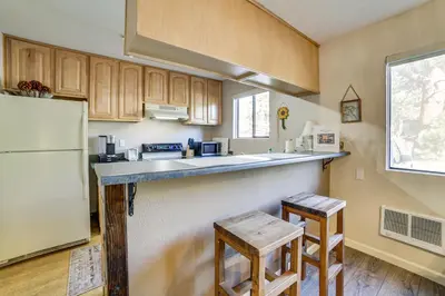a kitchen with a counter and a refrigerator and two stools at Cozy Mammoth Lakes Studio 5 Mi to Ski Slopes in Mammoth Lakes