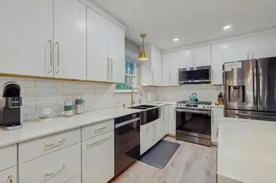 a kitchen with white cabinets and stainless steel appliances at Sierra Nevada Serenity in South Lake Tahoe