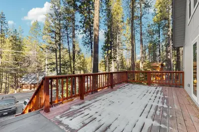a porch with a wooden deck with trees in the background at Sierra Nevada Serenity in South Lake Tahoe