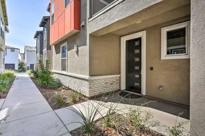 a building with a black door and a sidewalk at Pet-Friendly Elk Grove Retreat with Balcony! in Elk Grove