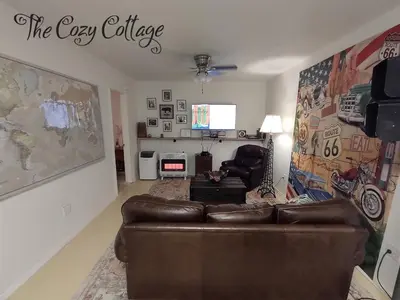 a living room with a leather couch and a tv at Cozy Cottage in Miramonte