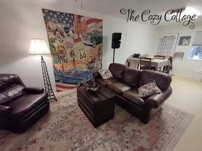 a living room with two leather couches and a table at Cozy Cottage in Miramonte