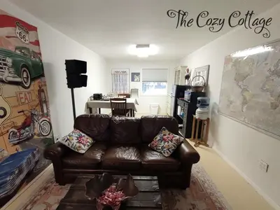 a living room with a brown leather couch at Cozy Cottage in Miramonte