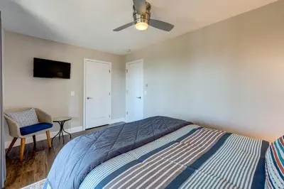 a bedroom with a bed with a ceiling fan and a chair at Casa Azul in Incline Village