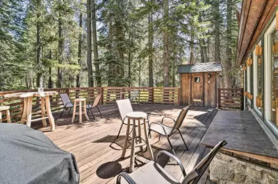 a deck with chairs and a table and a cabin at Waterfront Echo Lake Cabin with Deck, Mtn Views in Twin Bridges
