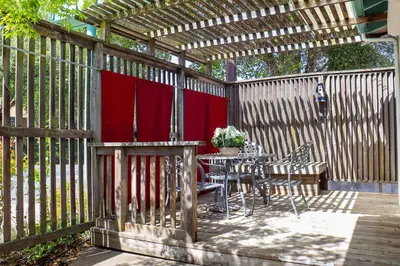 a wooden fence with a table and chairs on a patio at The Bonnie Inn Unit 5 with Breakfast Nook in San Andreas