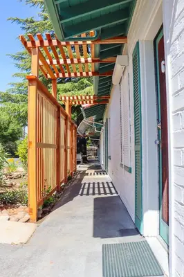 a wooden pergola on the side of a building at The Bonnie Inn Unit 5 with Breakfast Nook in San Andreas