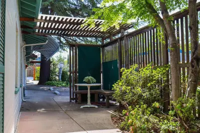 a patio with a wooden pergola and a bench at The Bonnie Inn Unit 5 with Breakfast Nook in San Andreas