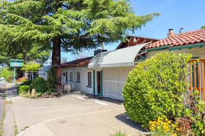 a house with a tree next to a street at The Bonnie Inn Unit 6 in San Andreas