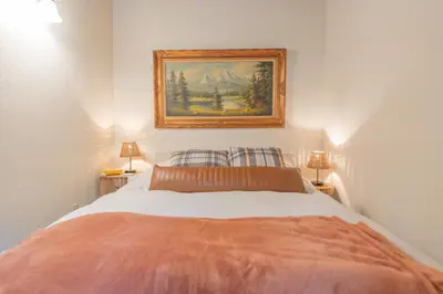 a bedroom with a bed with a painting on the wall at Sweet Arnold Cabin in Arnold
